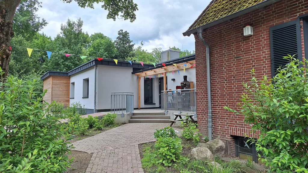 Gebäude der Kinderkreisel Kita mit Girlanden und Schuhabstellmöglichkeit für Kinder