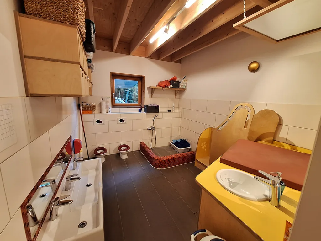 Badezimmer der Kinderkreisel-Kita Mäusegruppe mit Kindergerechten Toiletten, Waschbecken und Dusche