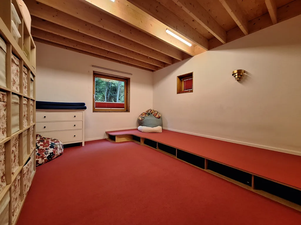 Schlafraum der Kinderkreisel-Kita Igelgruppe mit Regalen und Boxen zur Aufbewahrung von Bettzeug sowie freier Fläche zum Platzieren von Matratzen.