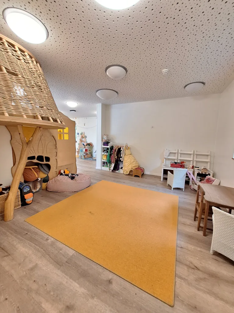 Spielraum der Kinderkreisel Kita mit Kletterburg, Sitzmöglichkeiten, Kostümen und Baueck
