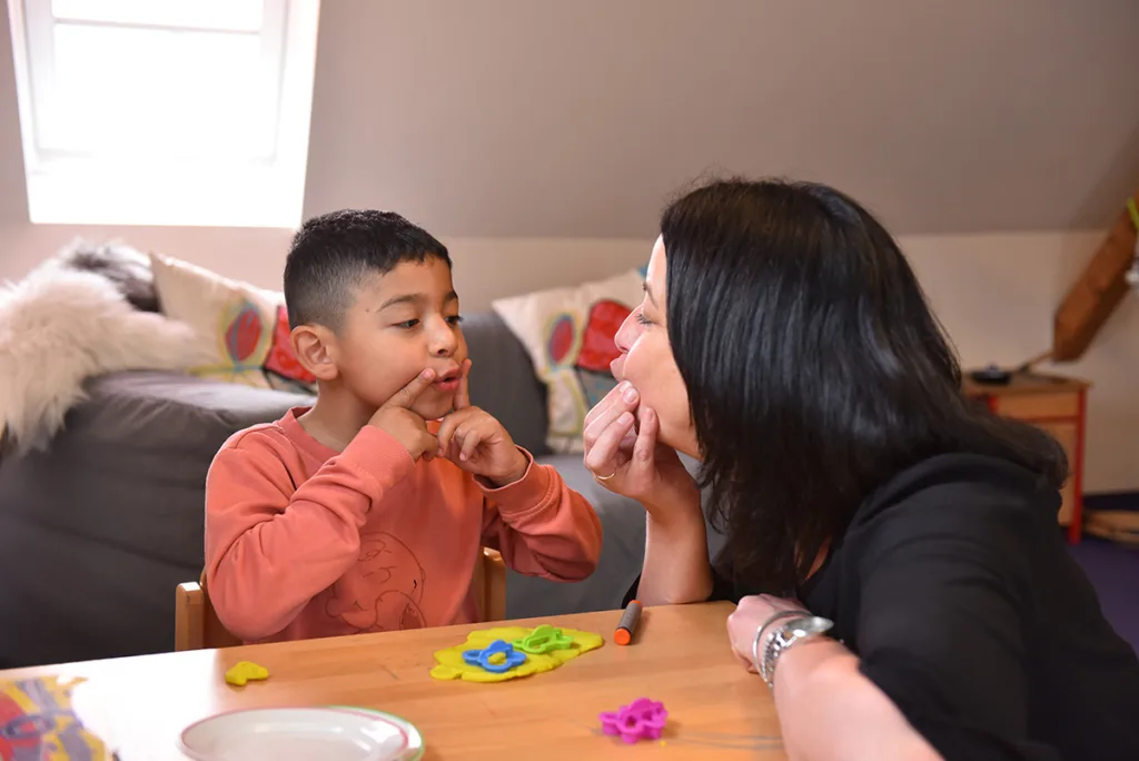 Erzieherin knetet gemeinsam mit einem Kind im Innenbereich der Kinderkreisel-Kita.